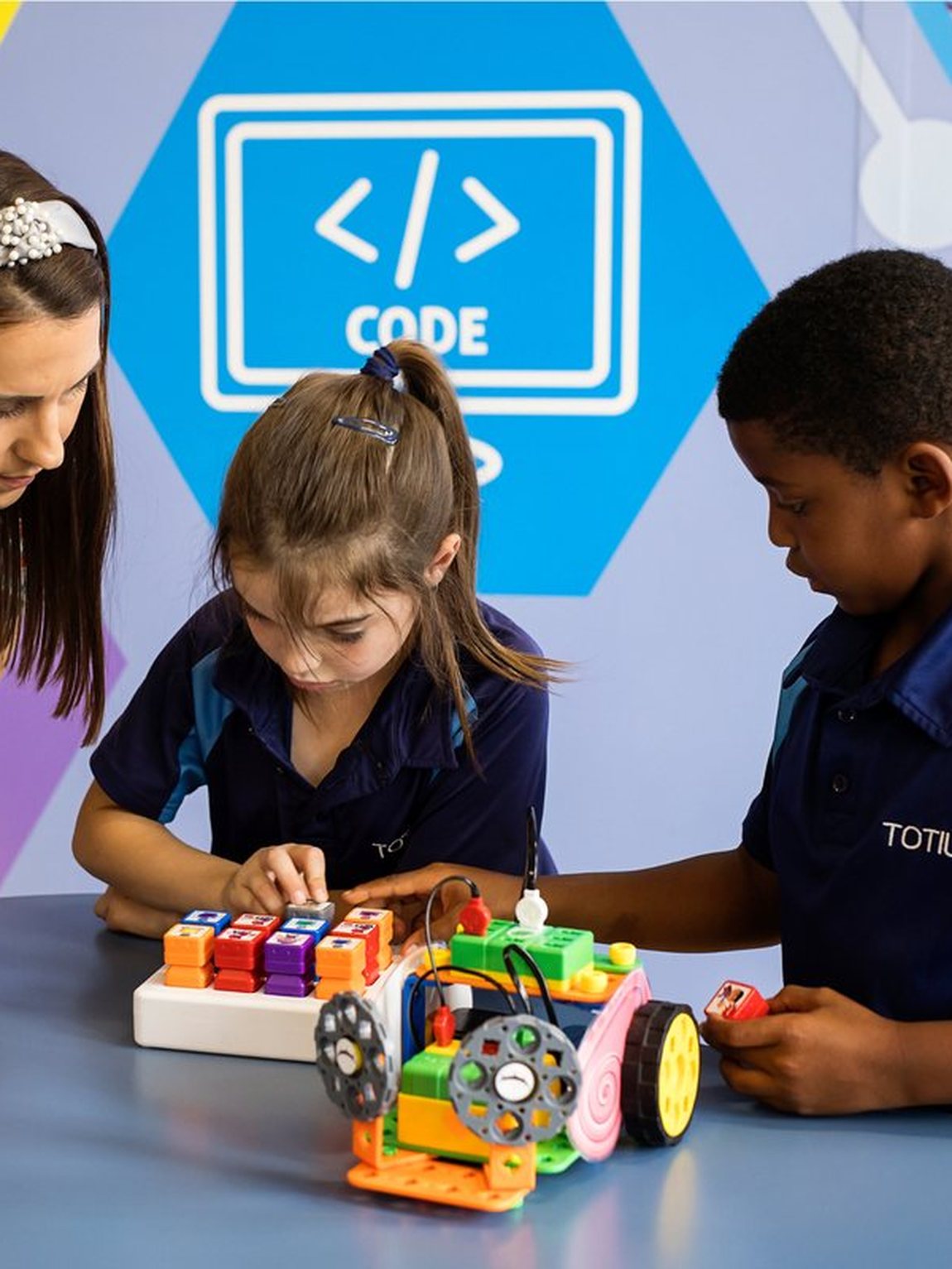 A teacher and two learners building a robot at Totius Primary